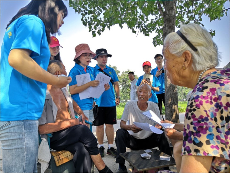 服务队成员给村民分发调研问卷